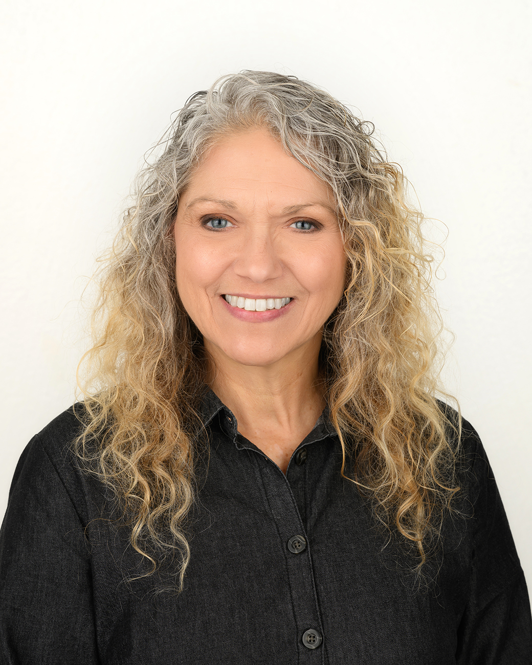 Woman smiling in black top with collar
